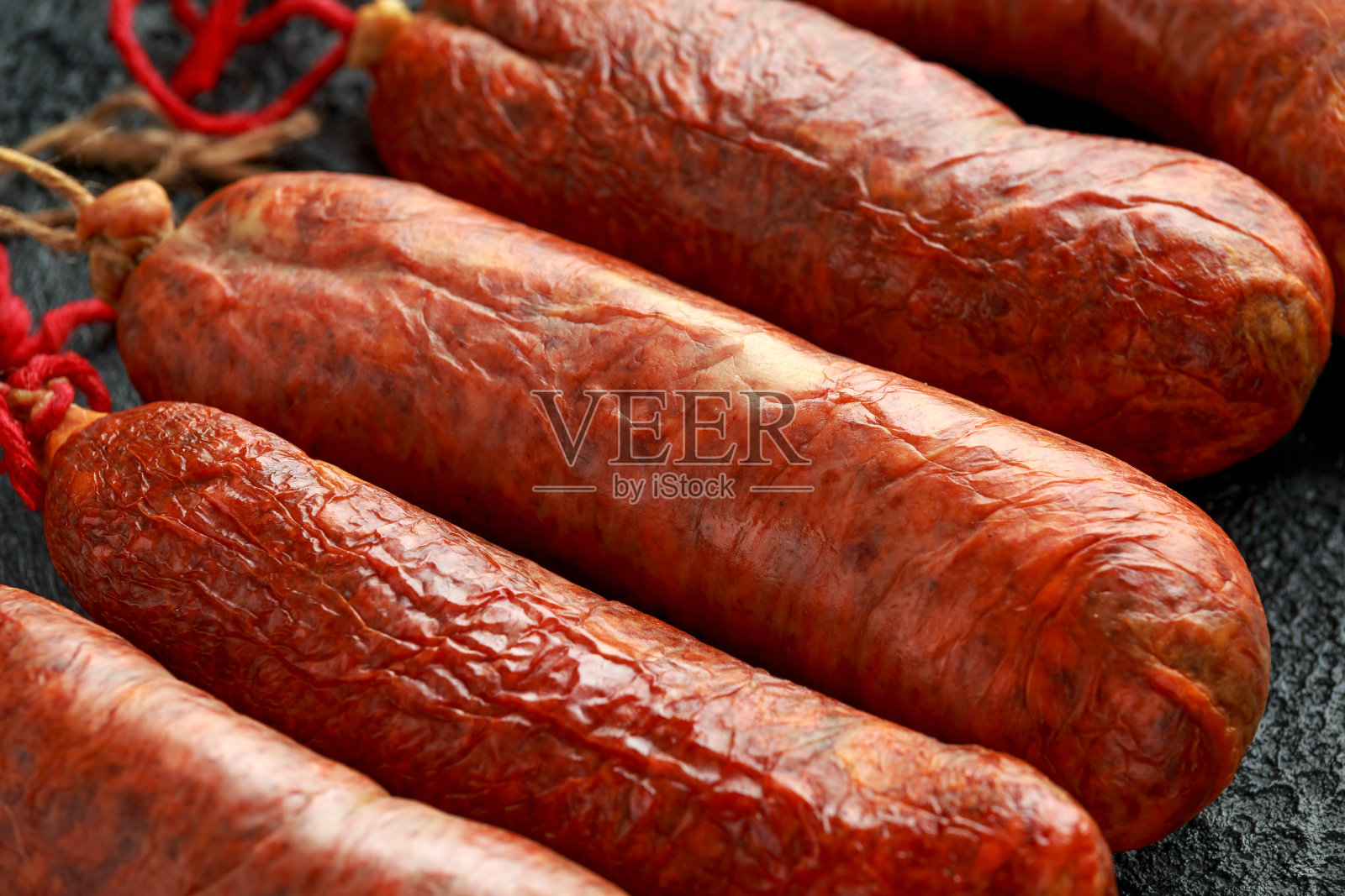 传统的巴利阿里生腊肠用猪肉末、辣椒粉和香料在乡村的黑色背景下制成照片摄影图片