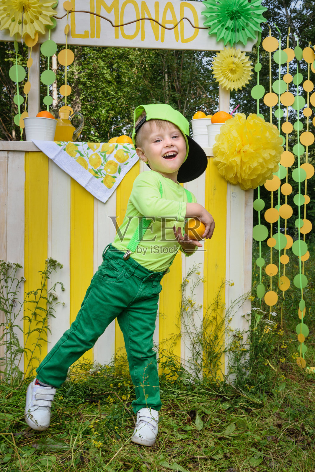 小男孩和柠檬跳舞在公园的柠檬摊附近照片摄影图片