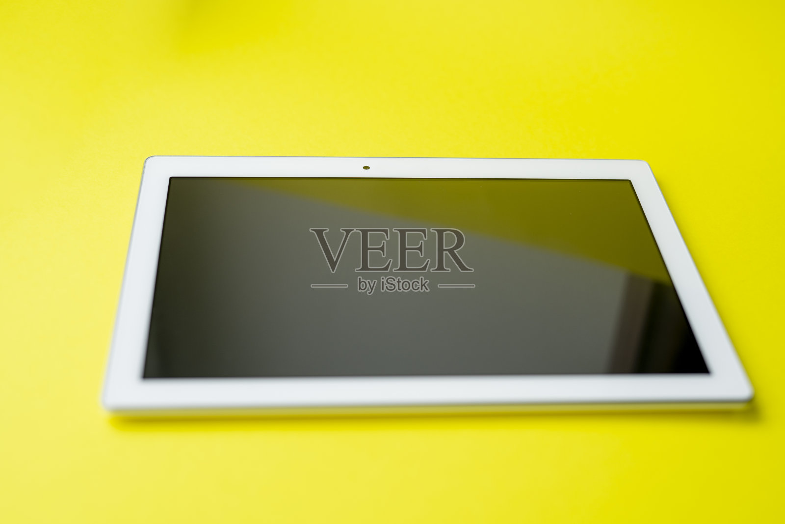 黄色背景上的白色平板照片摄影图片