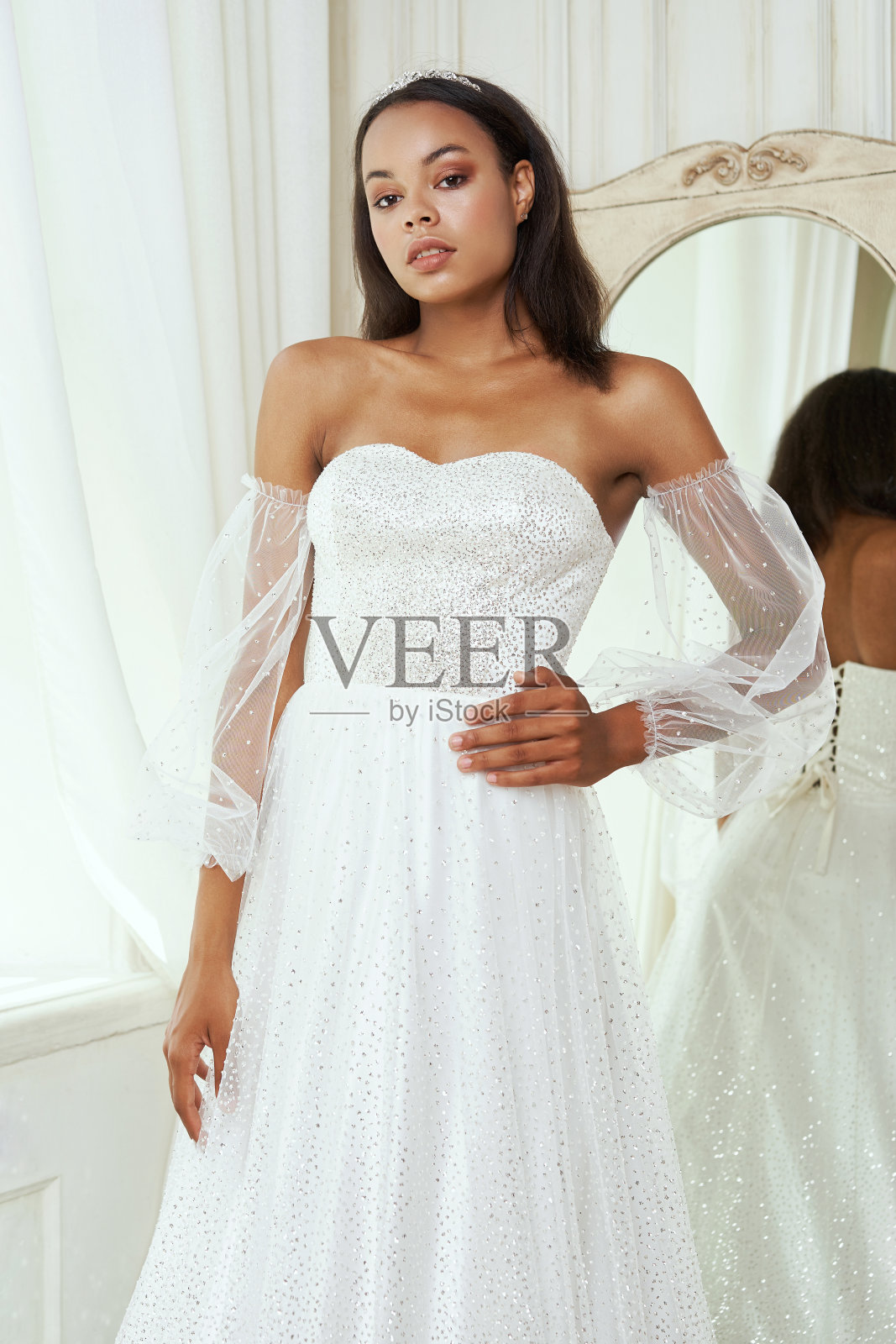 年轻的新娘站在窗口微笑照片摄影图片