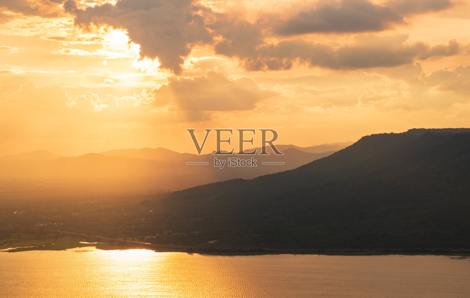 山景和日落与多云的金色天空。全景照片摄影图片