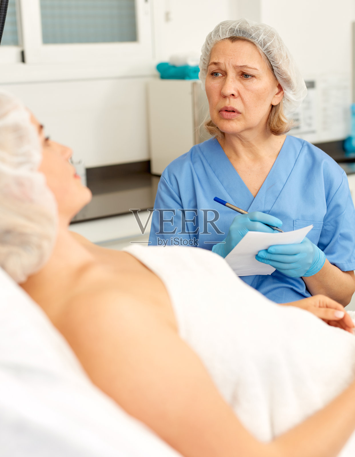 美容师在诊所给病人做民意调查照片摄影图片