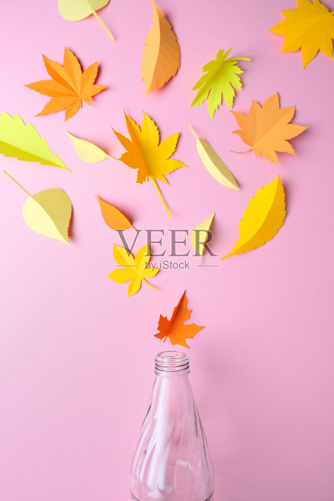 粉红色背景的纸做成的秋叶照片摄影图片