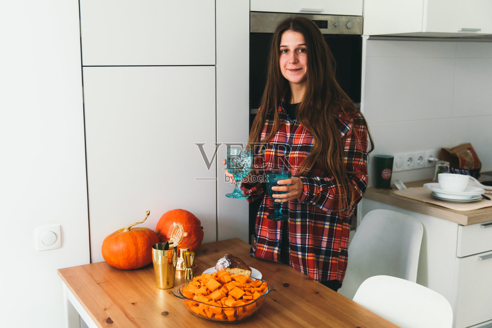 年轻的女人准备与朋友的晚餐-服务一个桌子与秋天的菜照片摄影图片