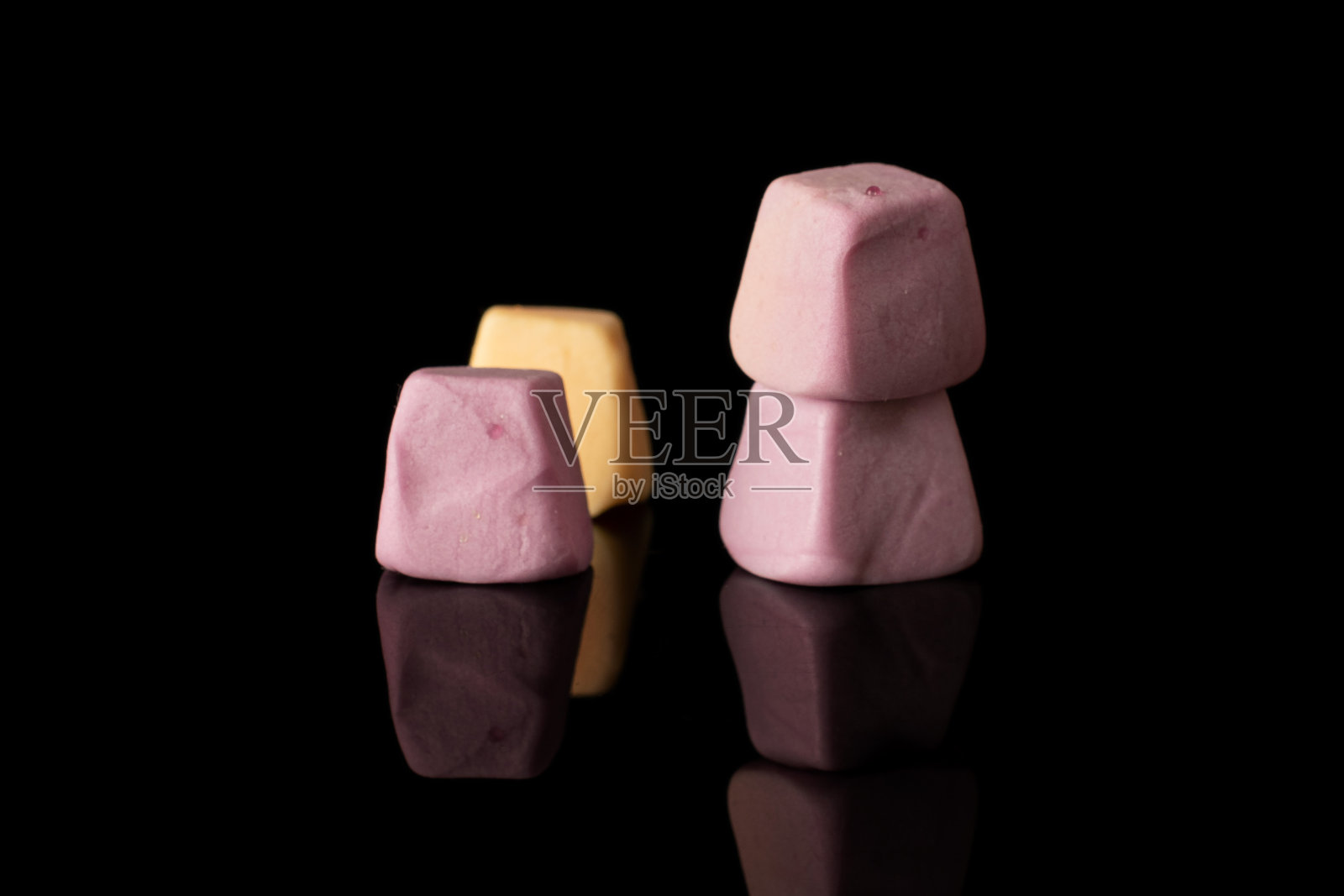 柔和的糖果孤立在黑色玻璃上照片摄影图片