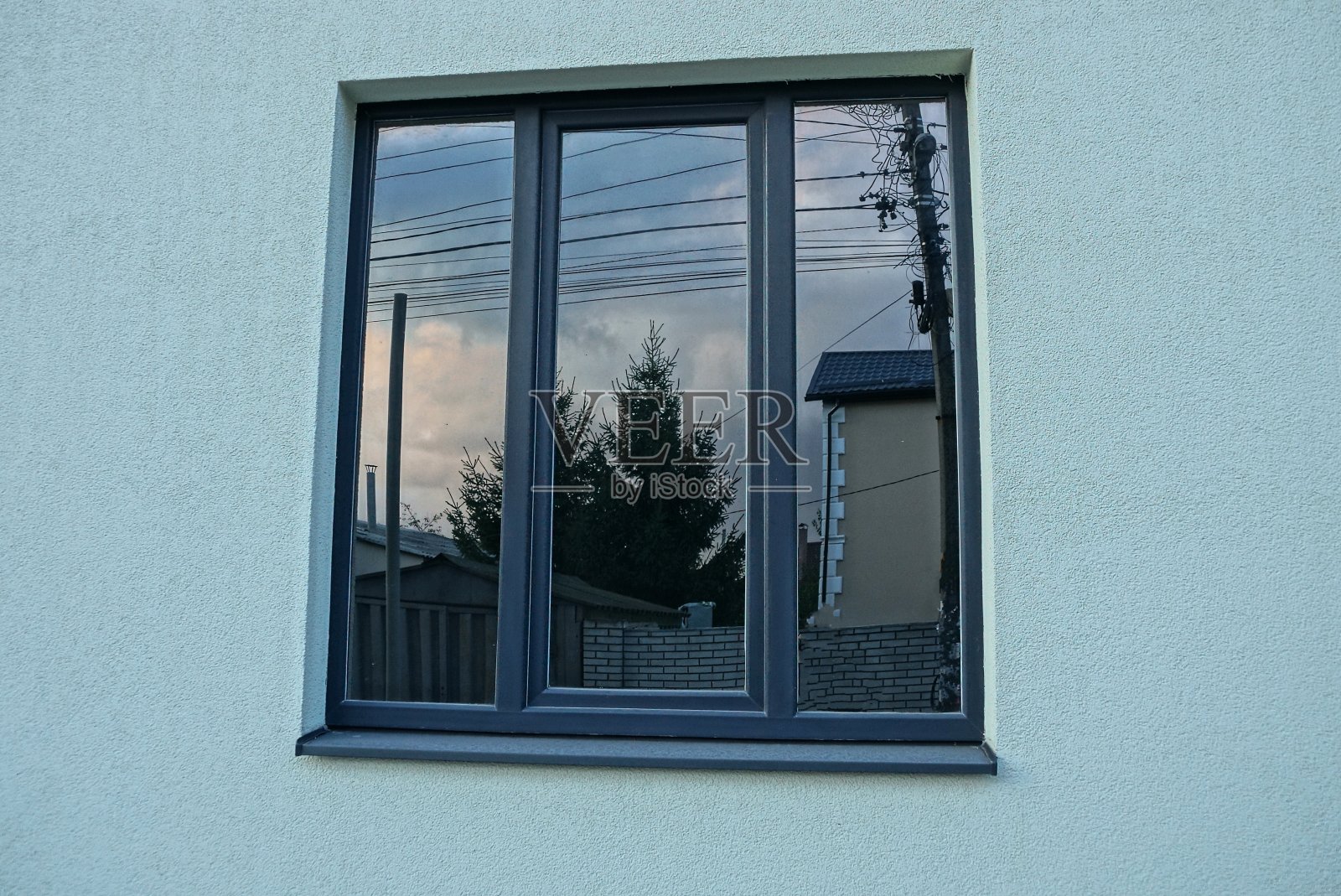 灰色的墙上有一扇蓝色的大窗户照片摄影图片