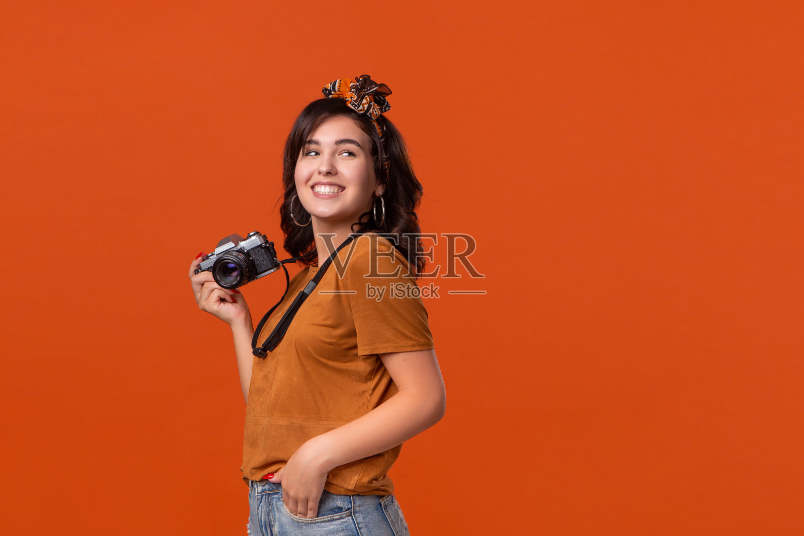 兴奋的黑发女人很高兴用她的相机拍摄。照片摄影图片