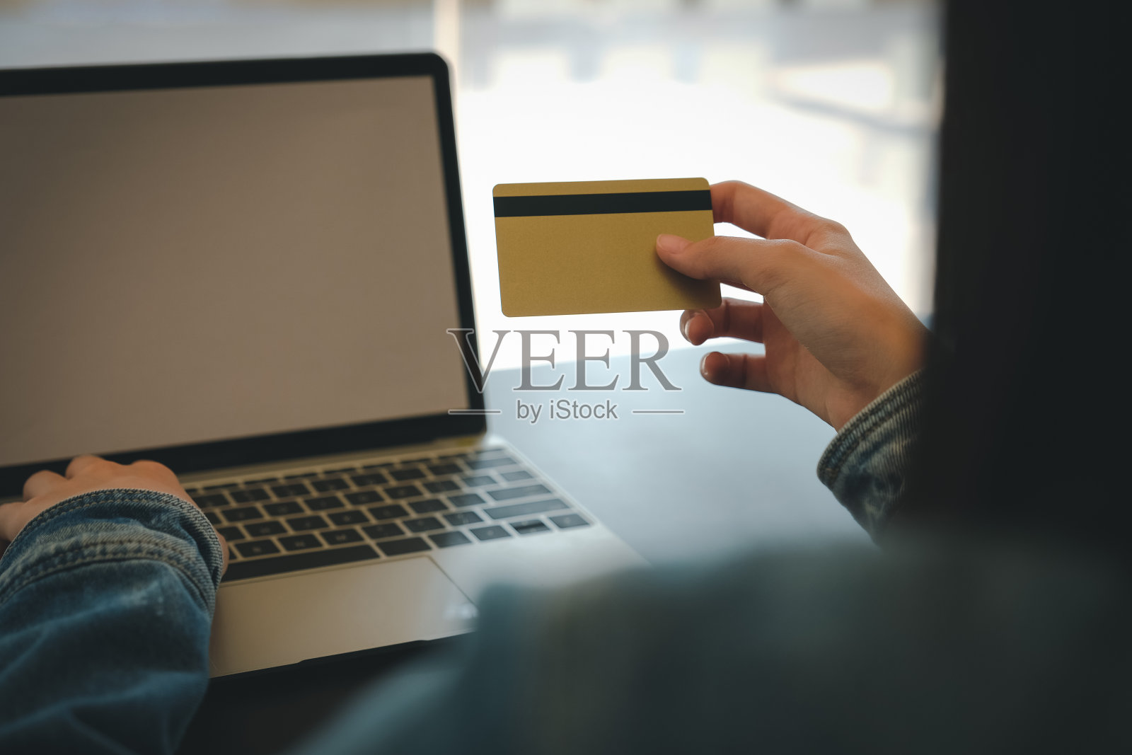 持卡用电脑网上购物的女子照片摄影图片