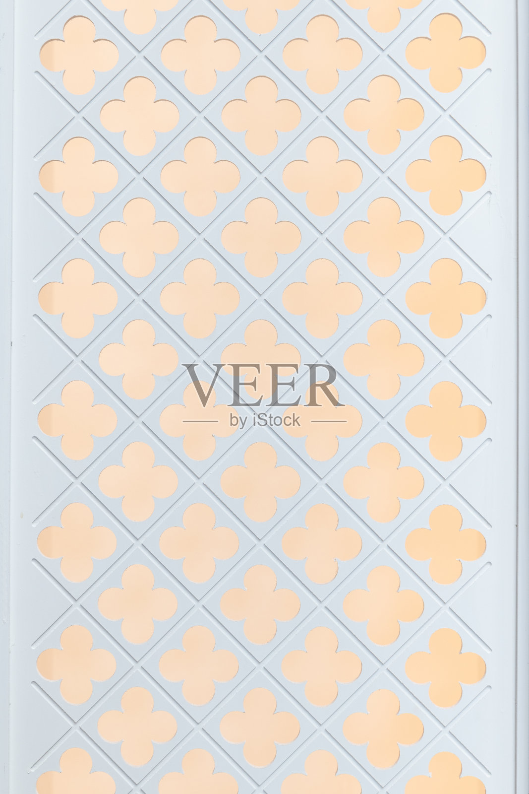 正面的木制白色隔断或背景与四叶三叶草图案洞和黄色光背景。照片摄影图片