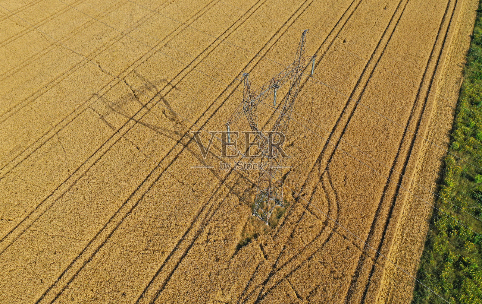 无人机俯瞰麦田中间的钢架高压塔照片摄影图片