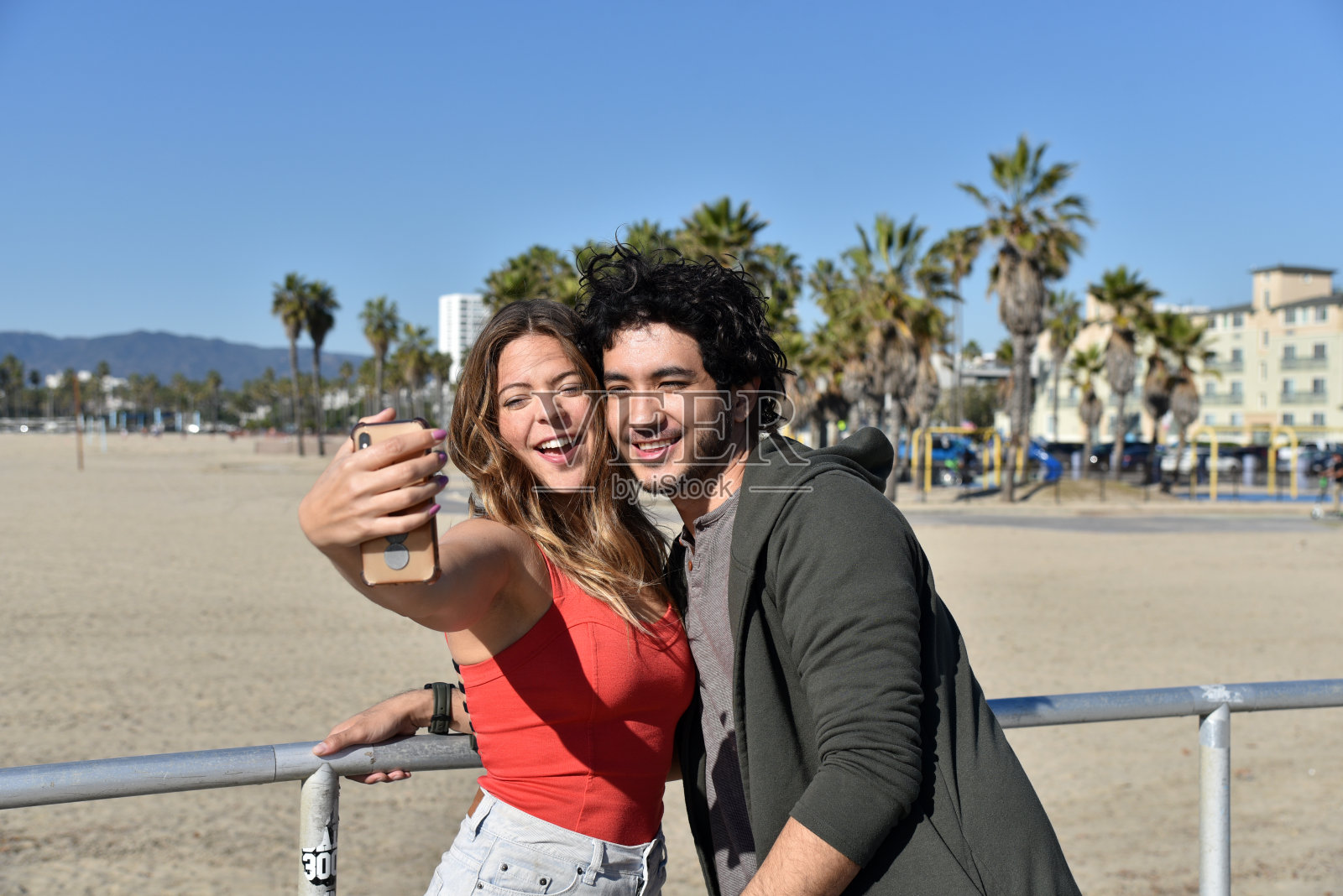 一对浪漫的小情侣在海滩上自拍照片摄影图片