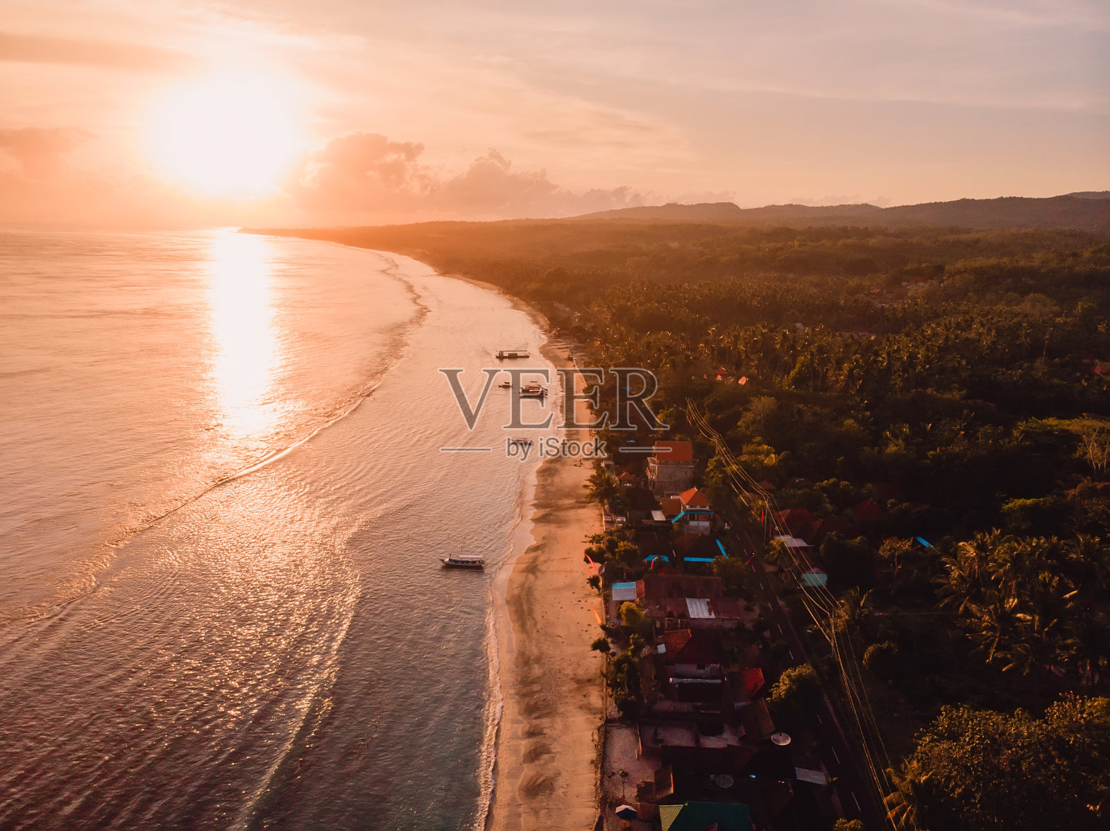沙滩,当地村庄和努沙佩尼达的海洋与日出的光线。鸟瞰图照片摄影图片