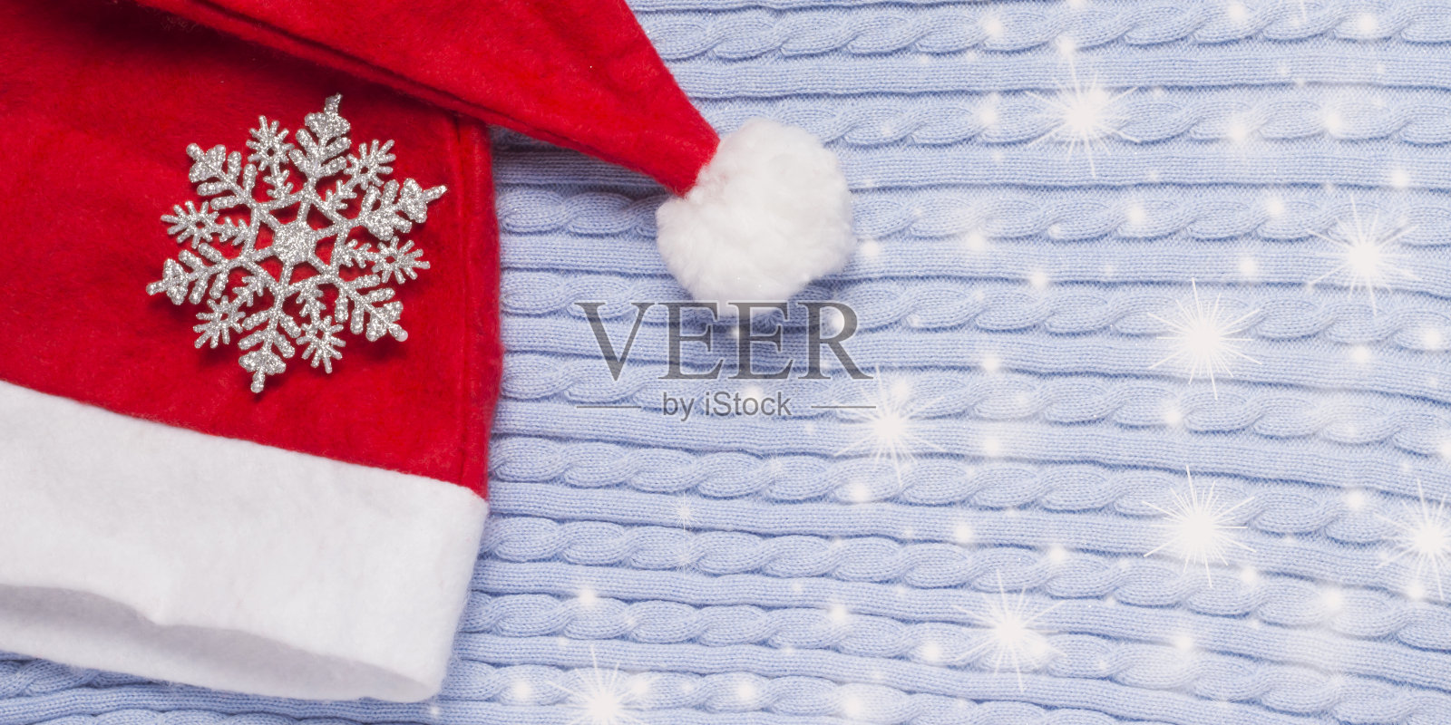 红色圣诞老人帽子与雪花在冬季蓝色背景与复制空间照片摄影图片