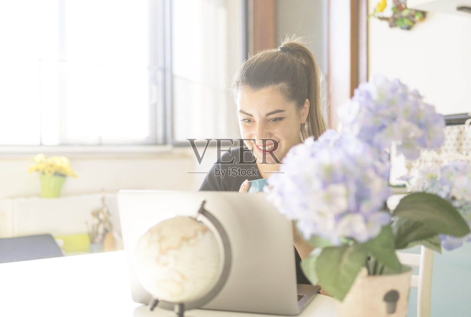 漂亮又快乐的女人在家用笔记本电脑工作。年轻女孩微笑着在网上购物照片摄影图片