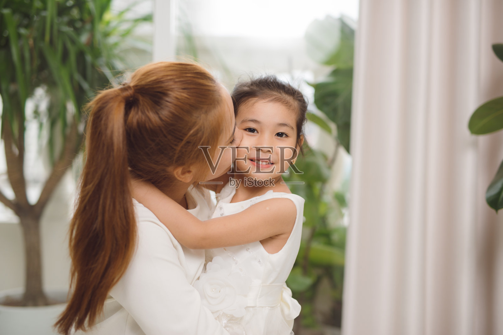 亚洲母亲和女婴笑着,拥抱着爱和幸福。照片摄影图片