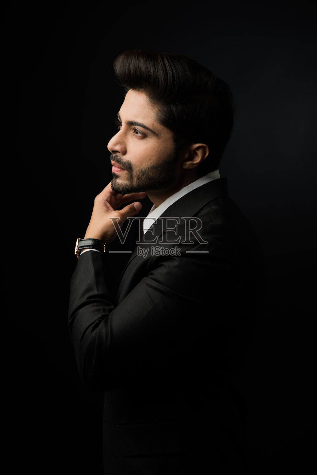 印度胡子男性商人显示侧面轮廓,站在黑色背景照片摄影图片