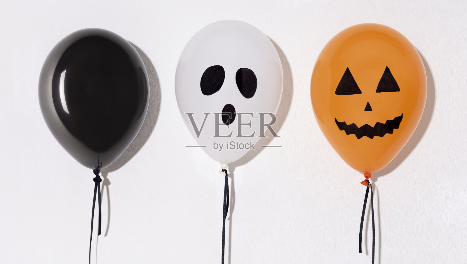 三个不同的万圣节气球,上面有白色的脸照片摄影图片