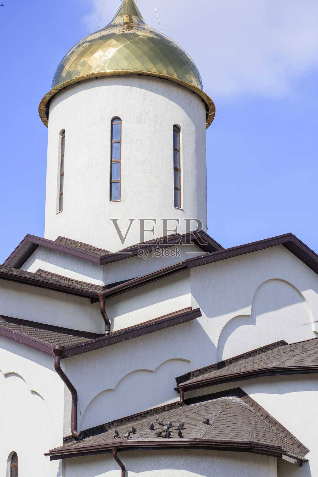 在晴朗的蓝天背景下的白色基督教教堂。城市建筑照片摄影图片