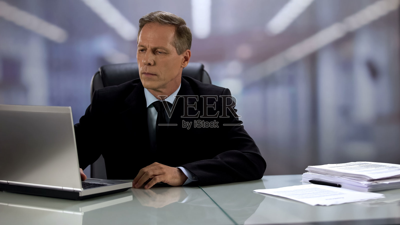 严肃的公司老板用笔记本电脑工作,回复电子邮件,很专业照片摄影图片