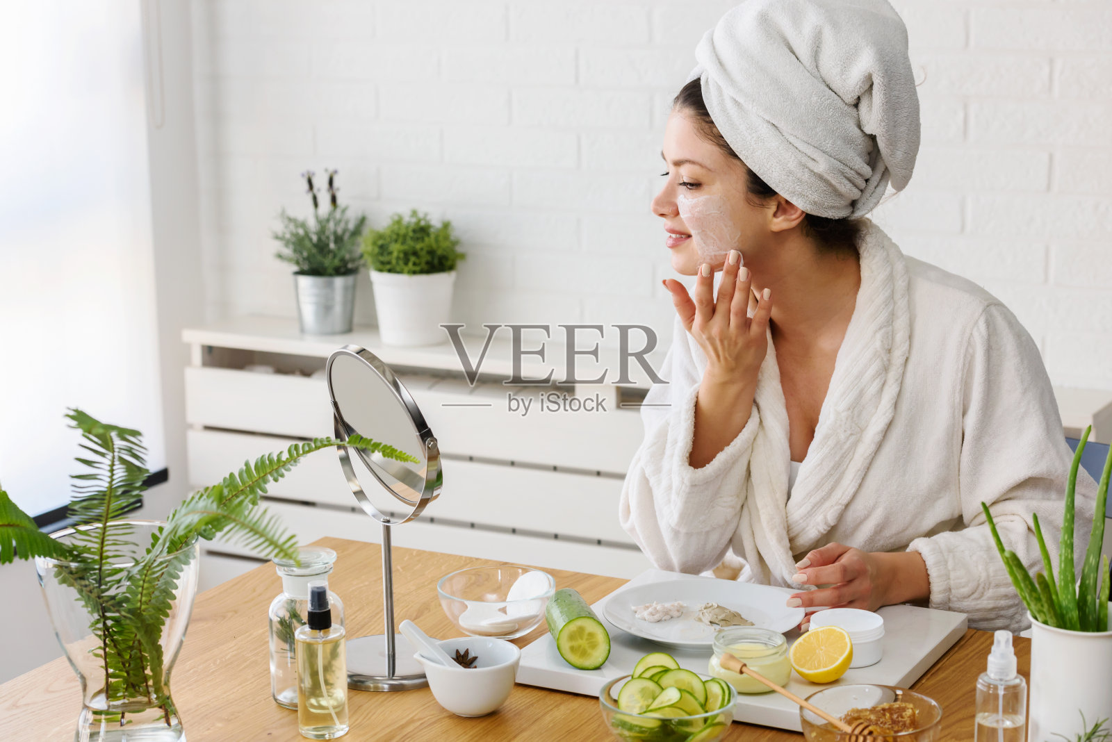 年轻女子在家里敷面膜。自然皮肤护理程序为容光焕发的皮肤。照片摄影图片