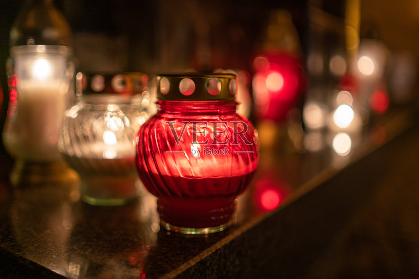 晚上在石头表面上放置点燃蜡烛的罐子照片摄影图片