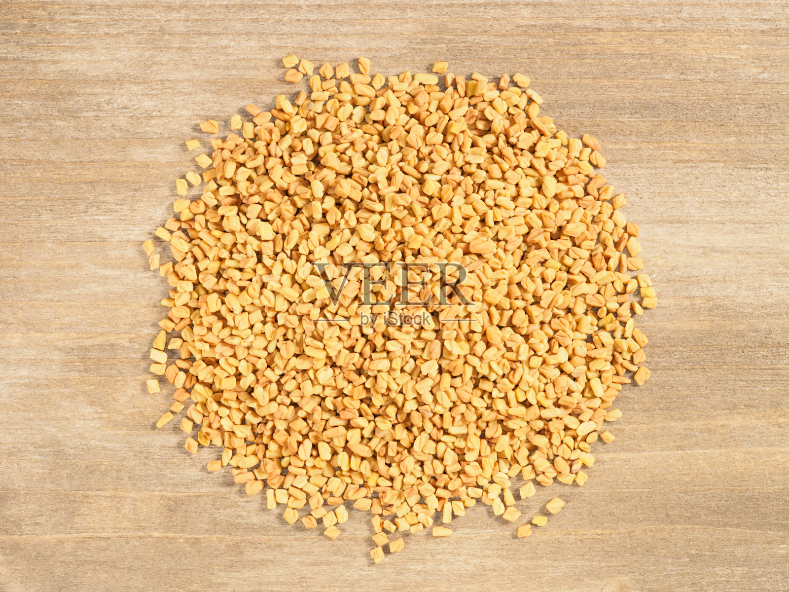 胡芦巴在棕色的木制背景上。印度烹饪,阿育吠陀,自然疗法,现代医药概念照片摄影图片