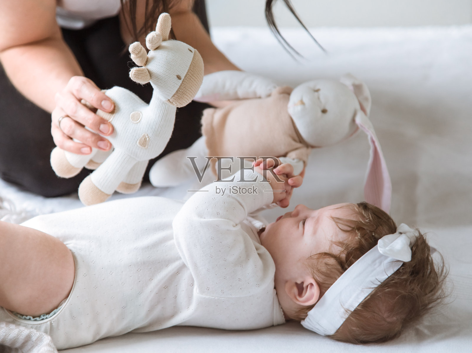 妈妈和刚出生的女儿玩玩具。照片摄影图片