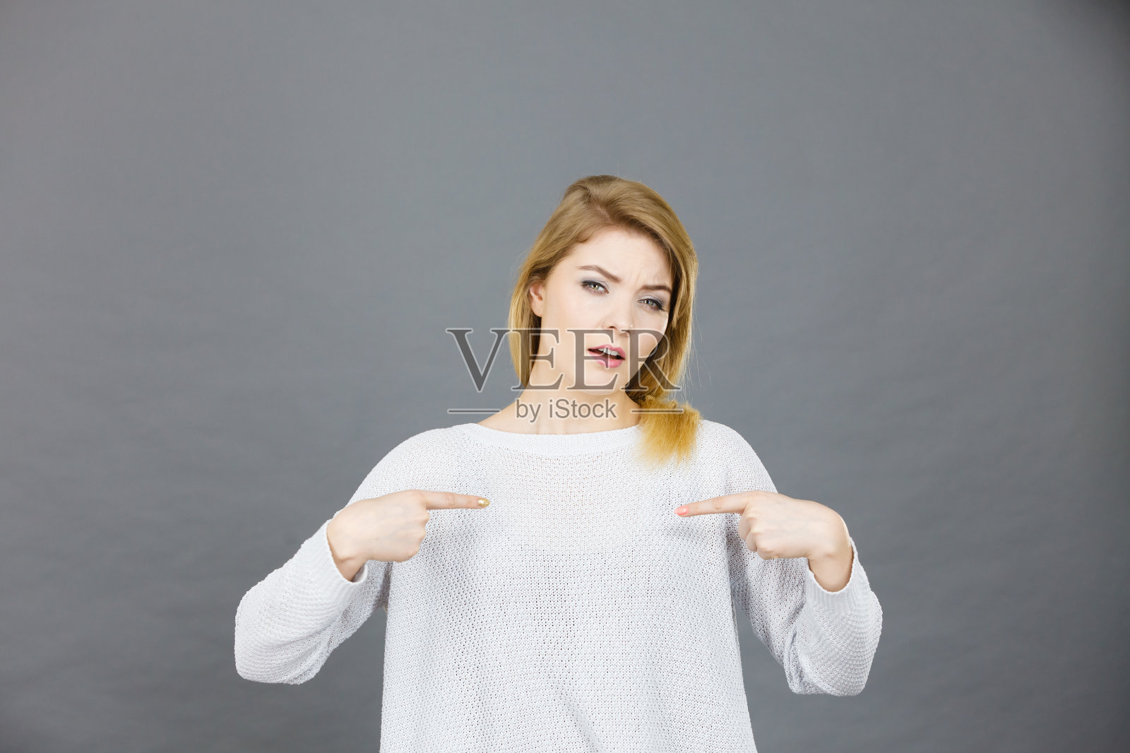 困惑的女人指着自己照片摄影图片