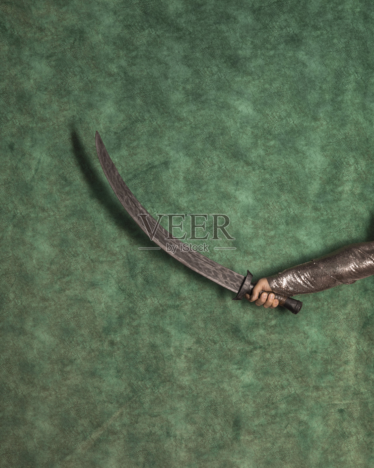 手与伊斯兰剑在绿色背景照片摄影图片