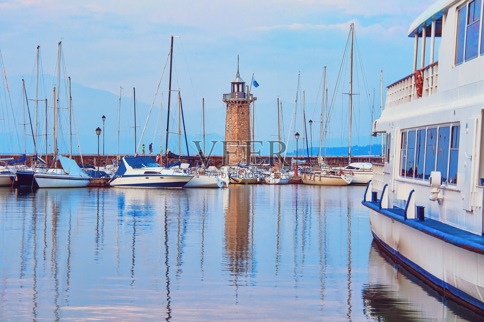 加尔达湖德赞诺灯塔附近港口的船只照片摄影图片