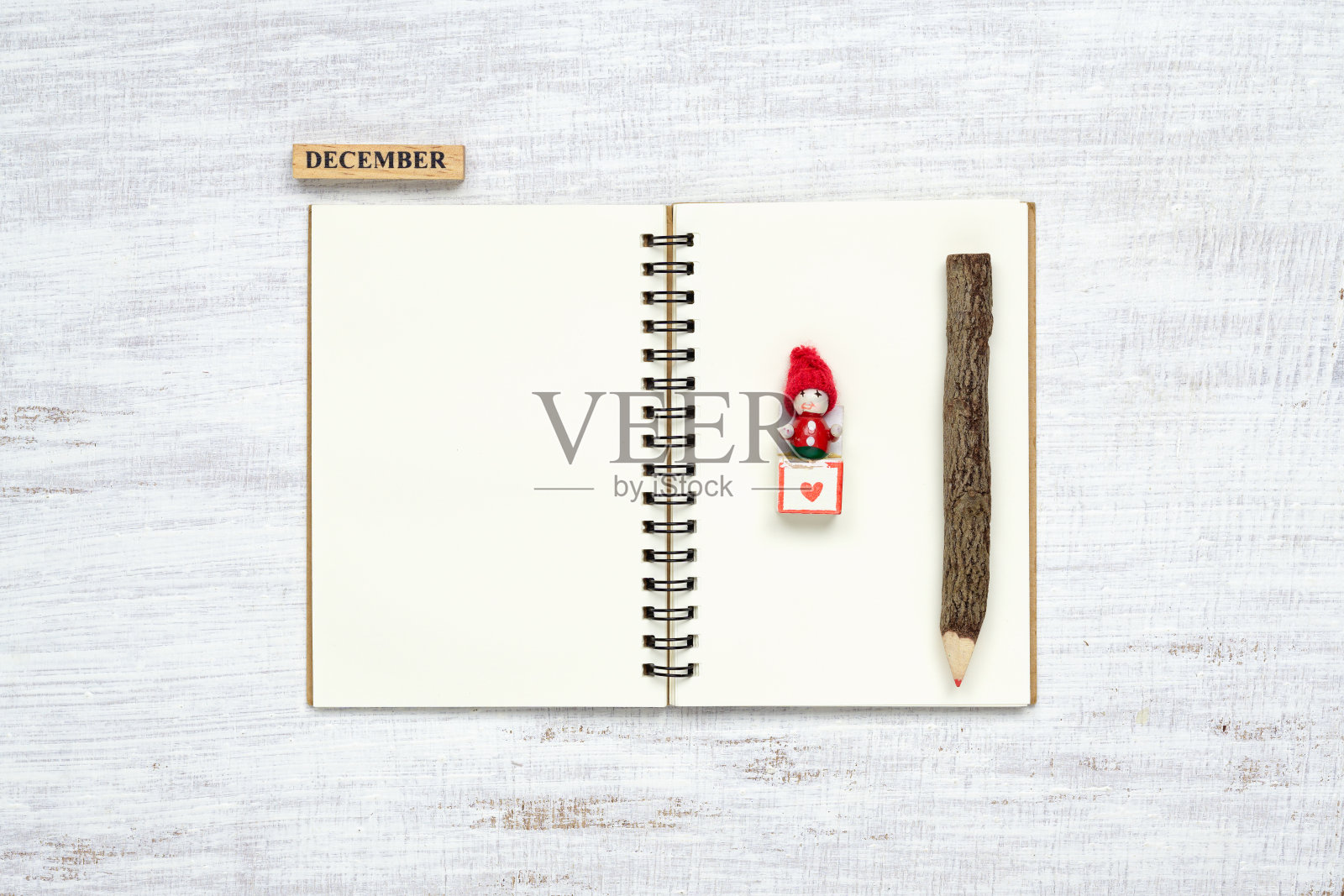 俯视图的空白笔记本在垃圾白色的木头背景与圣诞玩具装饰。原型圣诞背景与笔记本为愿望清单或要做的清单。平铺与拷贝空间。照片摄影图片