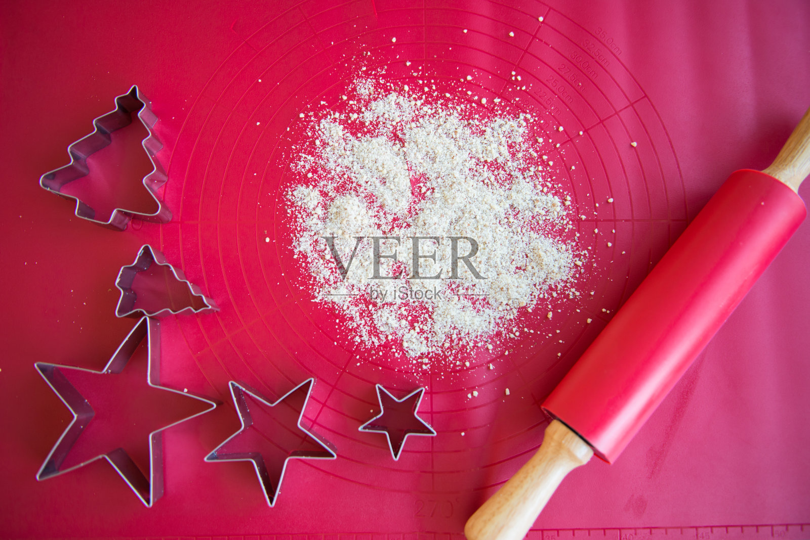 在制作圣诞饼干的过程中,模具、擀面杖、不同的形状和面粉的特写。从上面的观点照片摄影图片