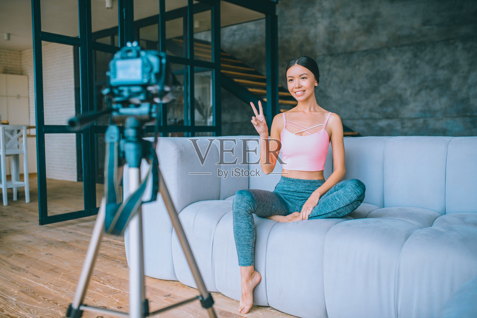 年轻的视频博主穿着灰色紧身裤拍摄视频照片摄影图片