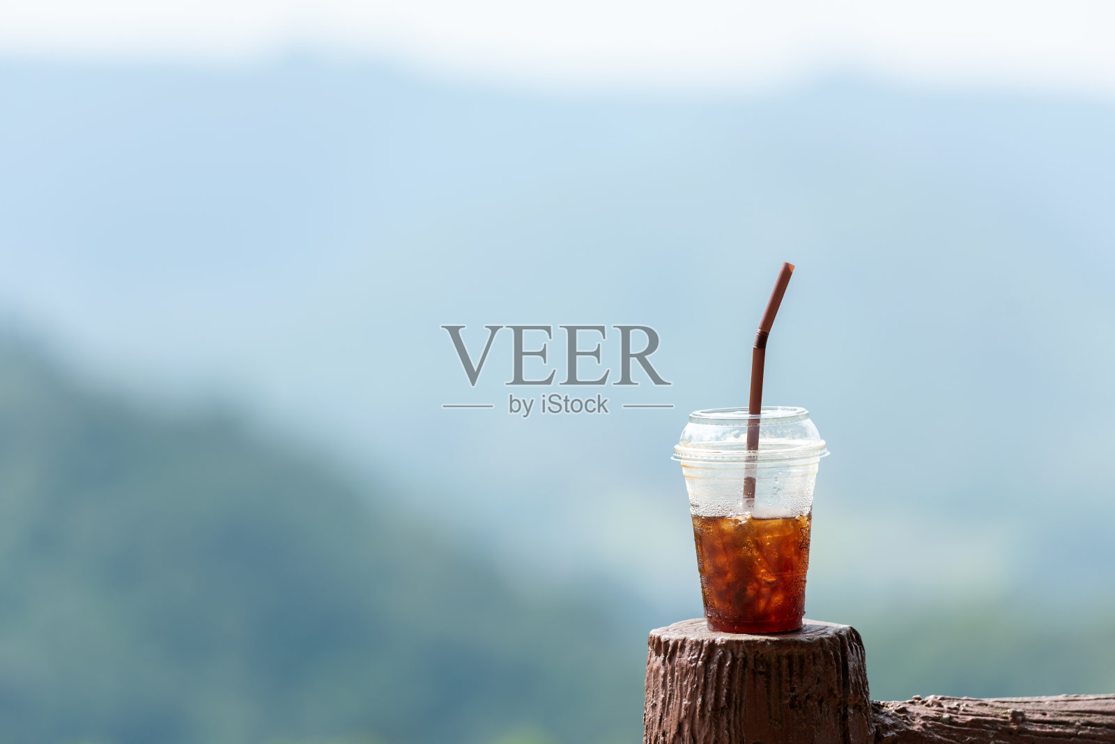 在户外的树木上喝杯冰咖啡。美丽的自然背景。生活方式的概念照片摄影图片