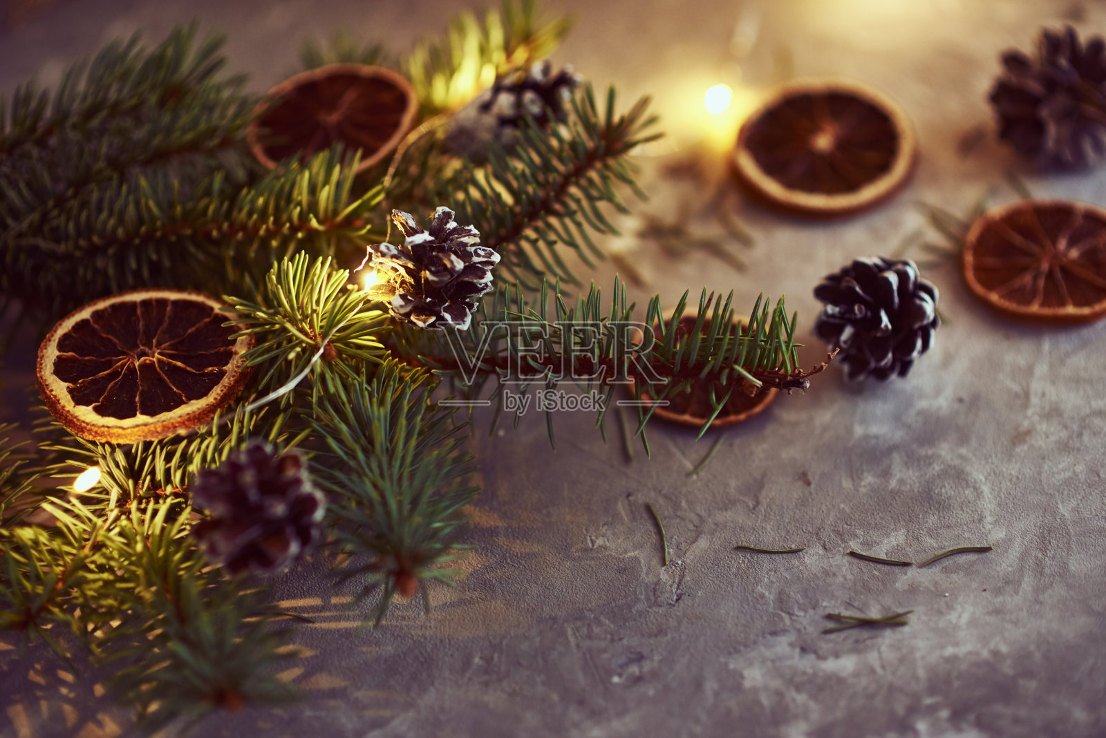 圣诞装饰用花环灯,松果和冷杉树枝在黑暗的背景照片摄影图片