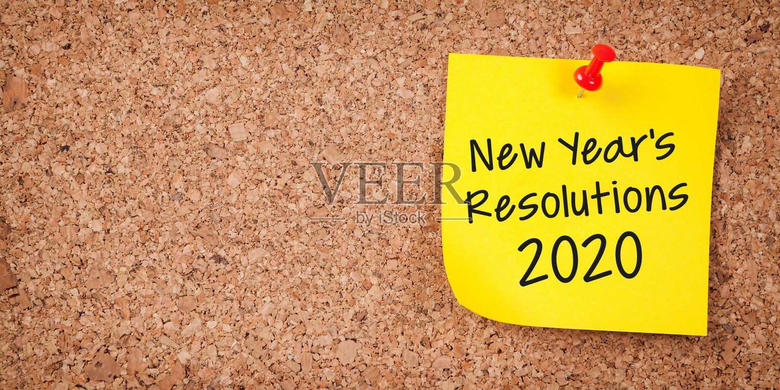 黄色便签上写着2020年新年决心和软木板上的红色大头钉照片摄影图片