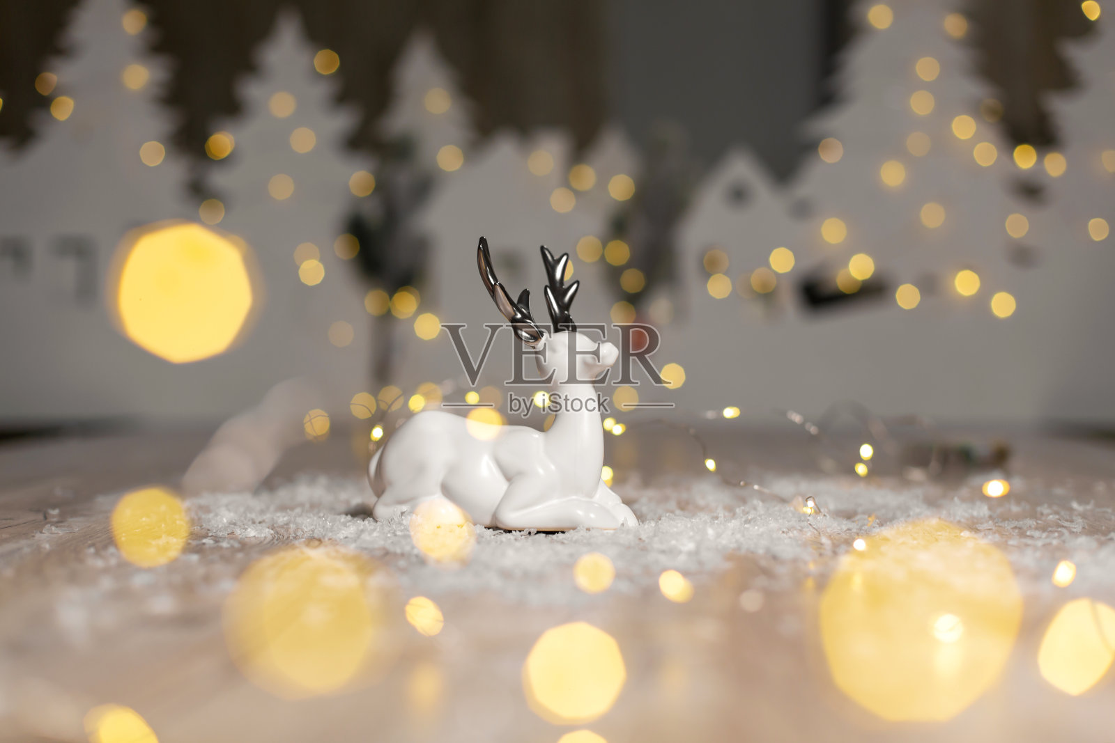 装饰以圣诞为主题的雕像。圣诞鹿。圣诞树装饰。节日装饰,温馨的散景灯。照片摄影图片