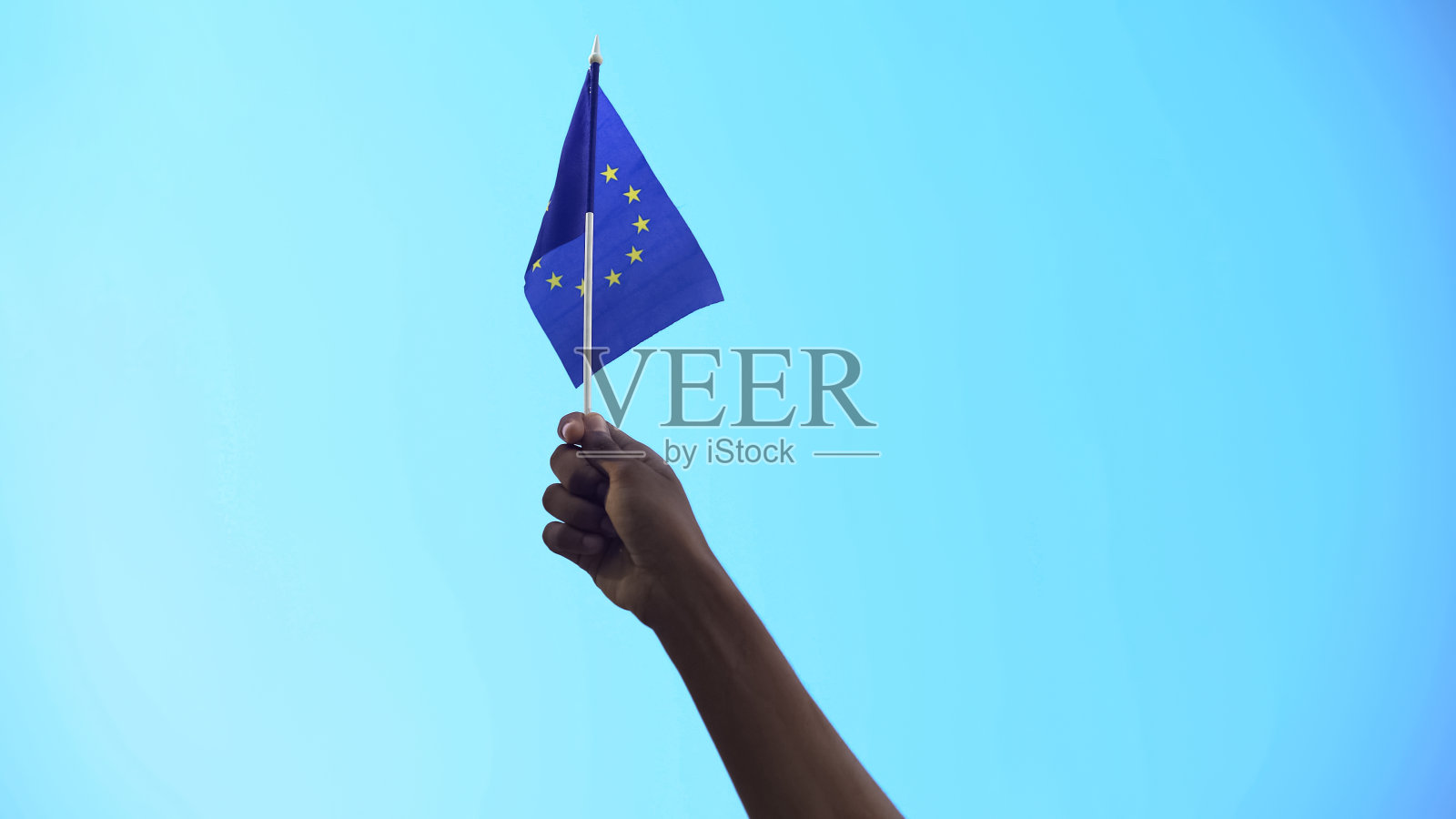 在天空背景上举着欧洲国旗的人,为自由和团结而游行照片摄影图片