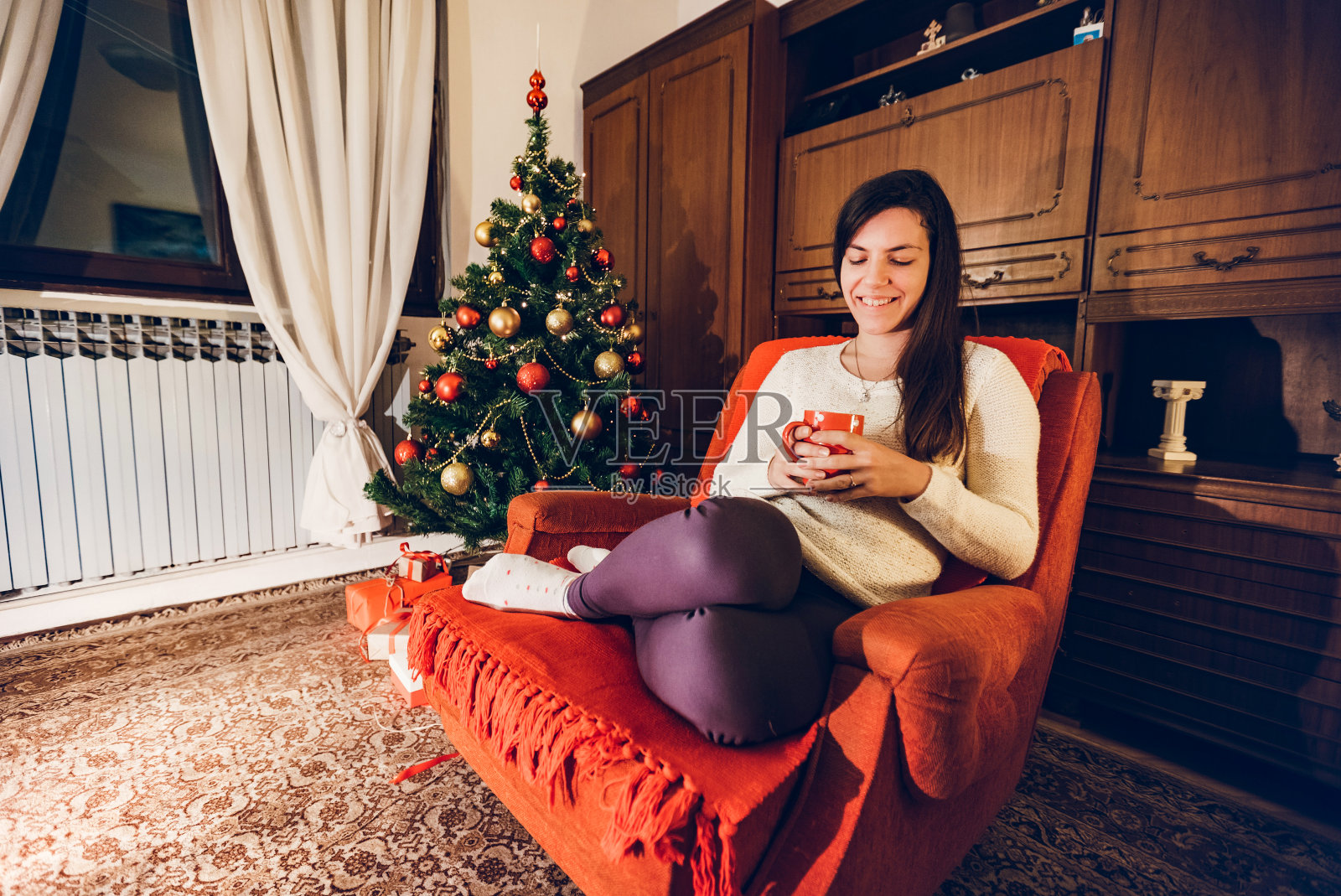 在圣诞树旁喝咖啡照片摄影图片