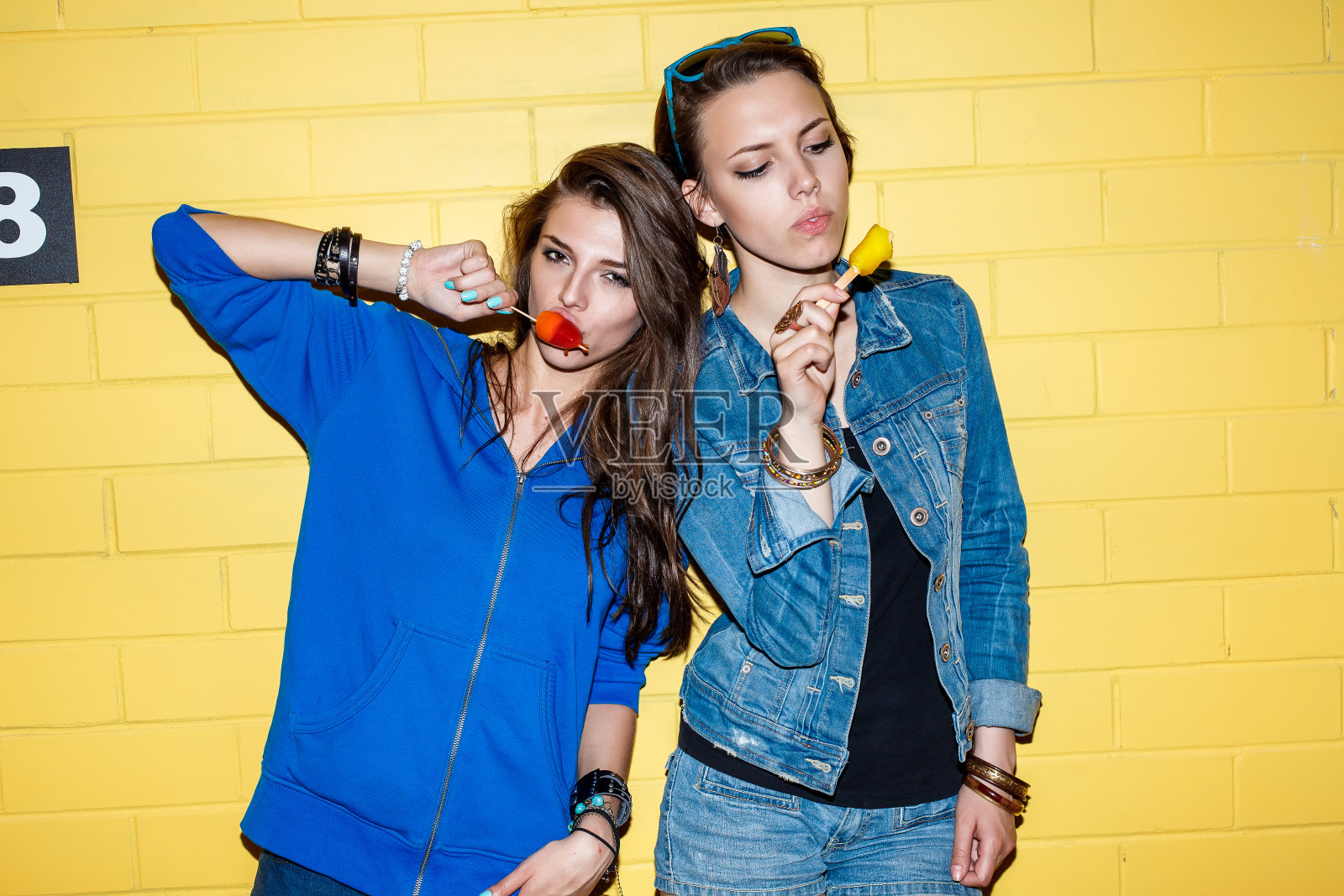 快乐的年轻人在黄砖墙前玩耍照片摄影图片