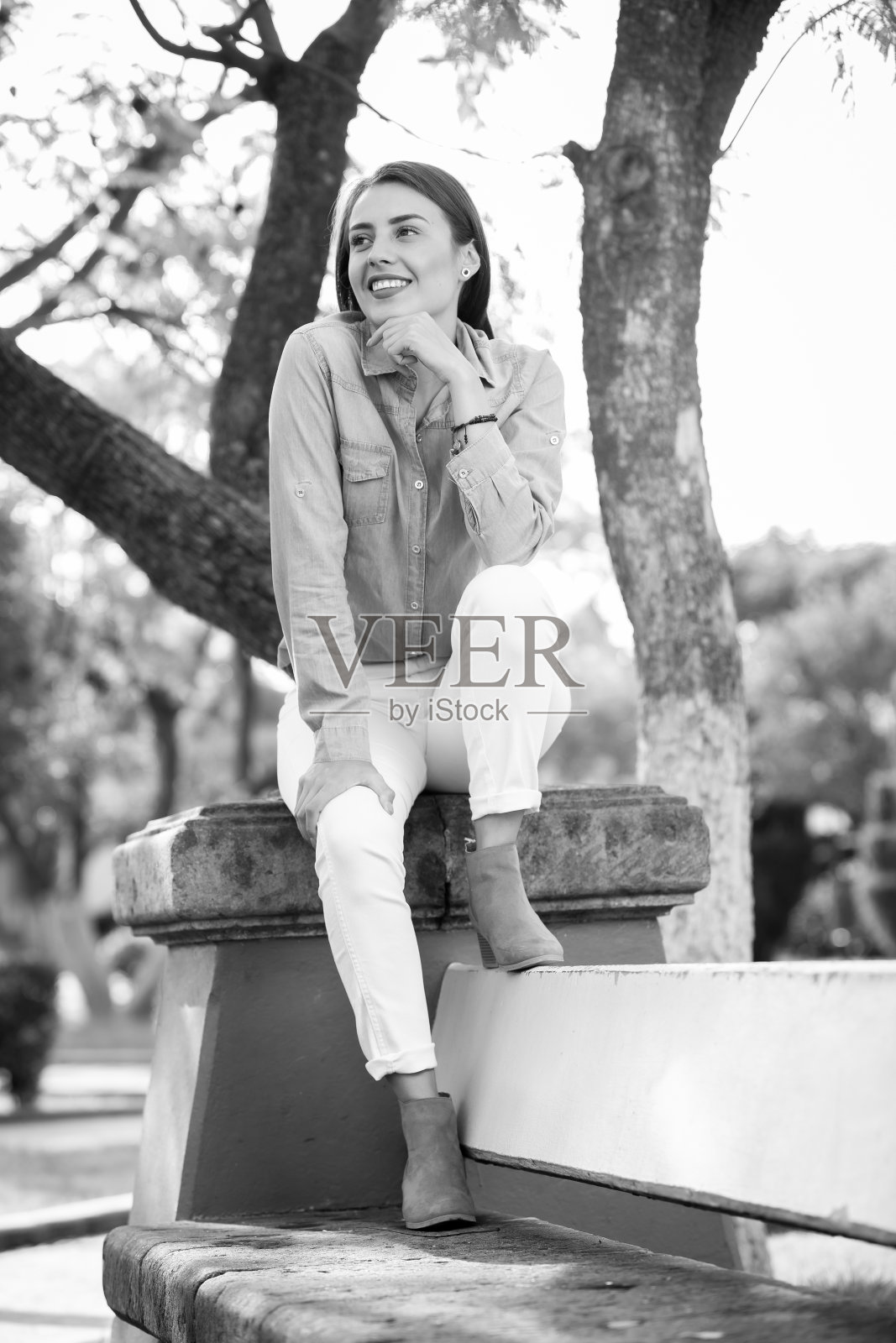 穿着蓝色衬衫和白色裤子的年轻女子照片摄影图片