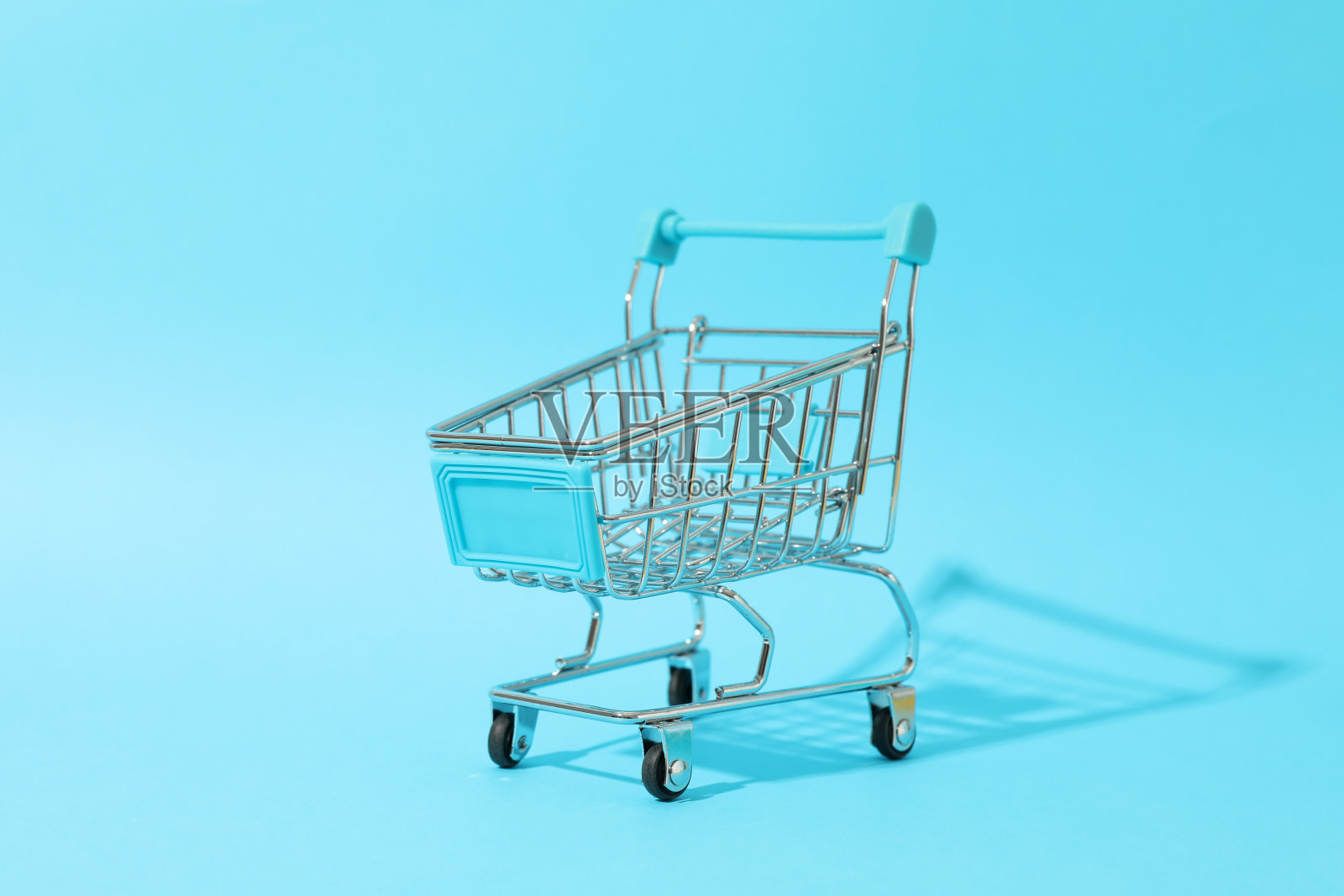 小购物车在蓝色背景,文字空间照片摄影图片