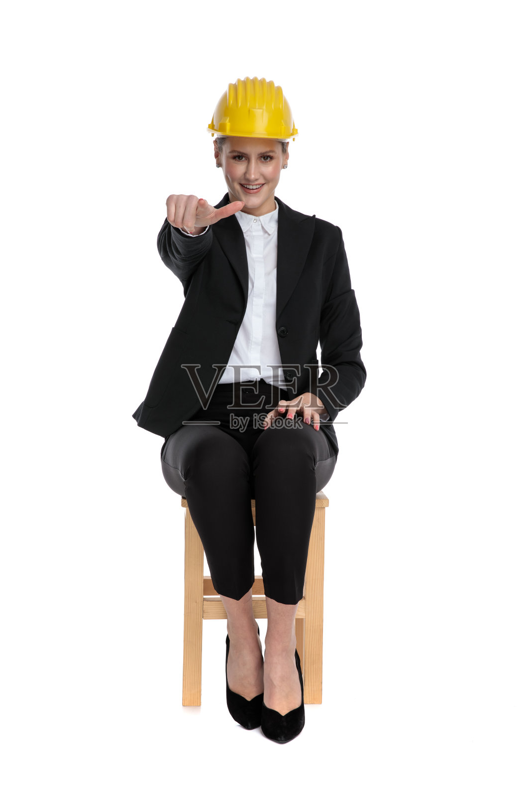 女商人戴着黄色的头盔,指着前方照片摄影图片