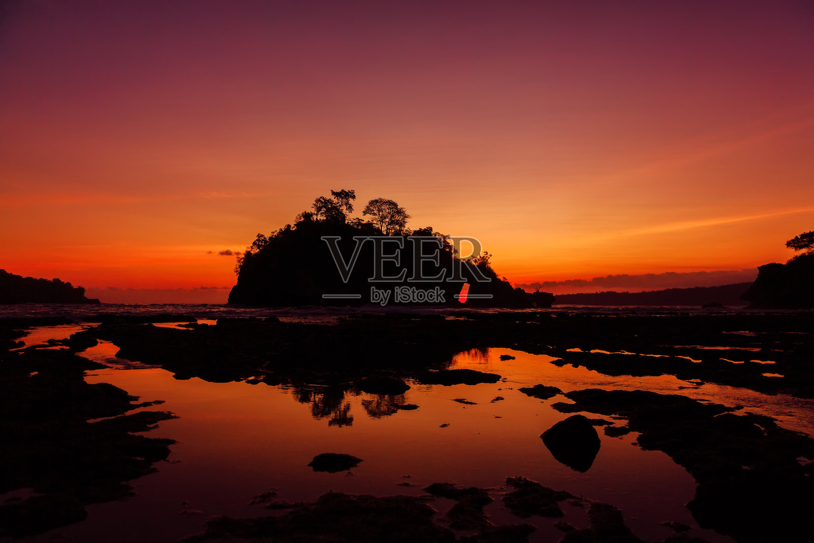 在巴厘岛努沙佩尼达的海洋岩石岛与明亮温暖的日落照片摄影图片