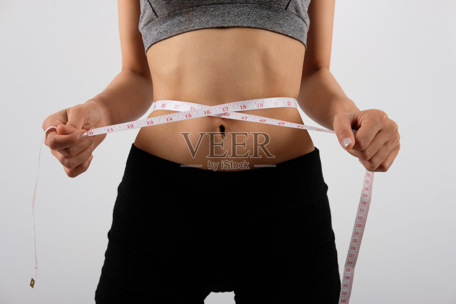 运动健身妇女在运动服装与测量腰围与带子。健康体育生活方式照片摄影图片