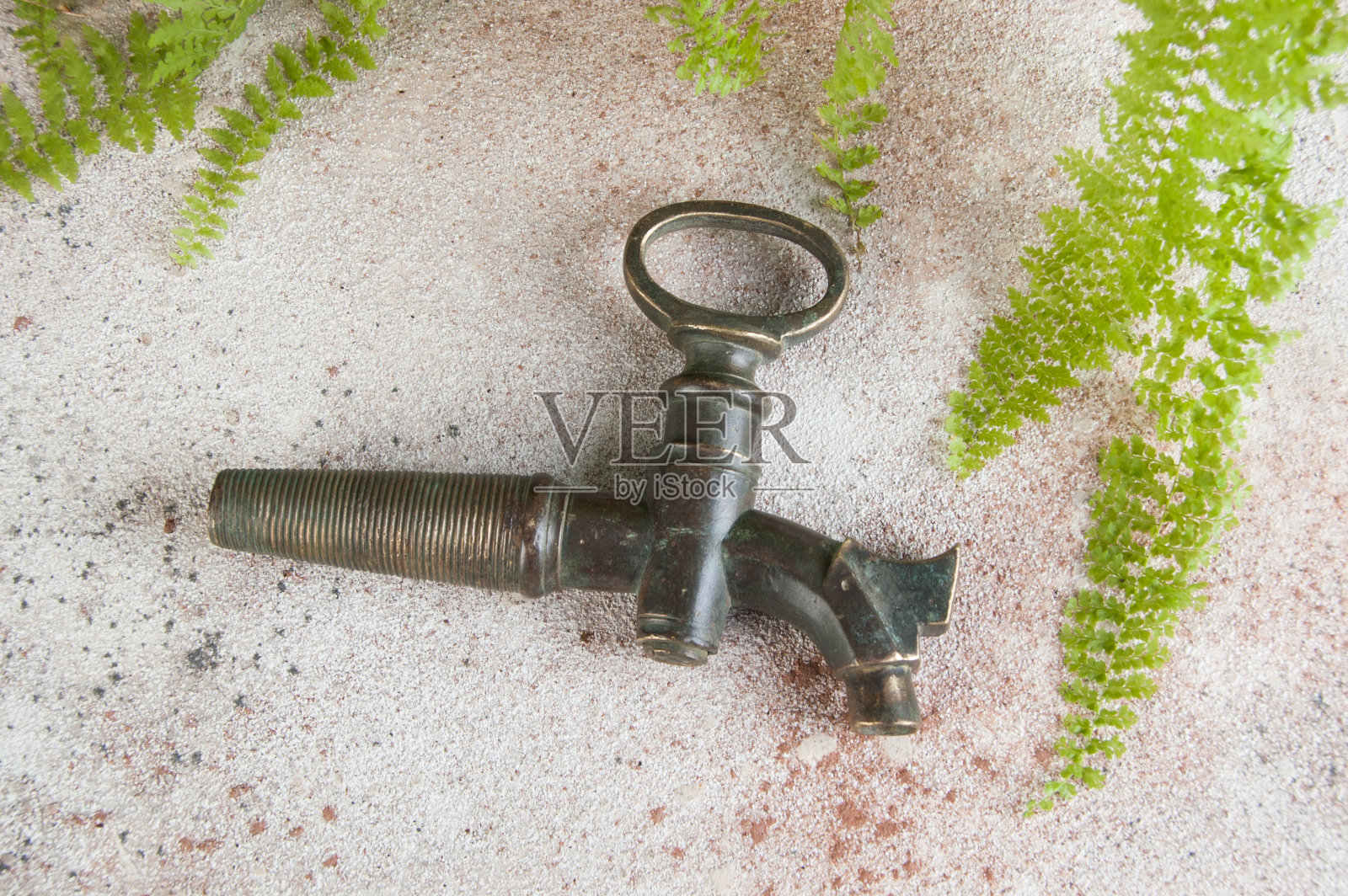 混凝土背景上的古董青铜酒桶起重机。照片摄影图片