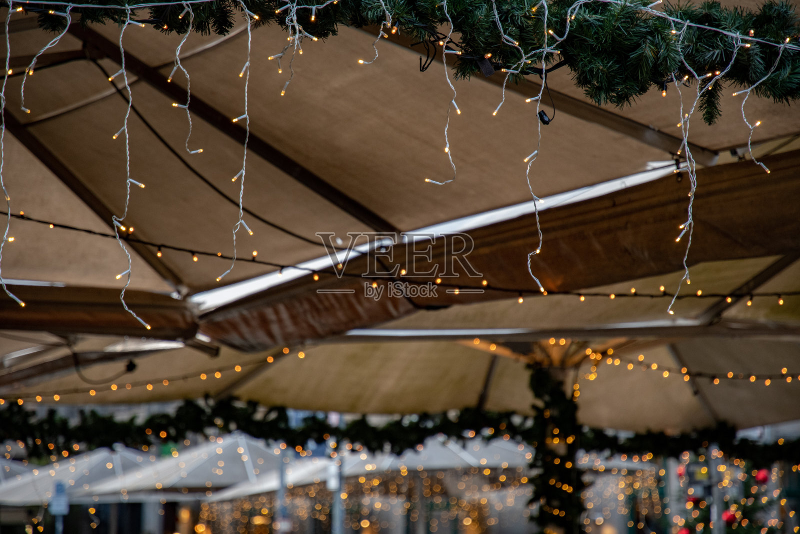 圣诞彩灯花环的抽象背景。古老的遮阳篷下闪着金光。不同寻常的新年背景。多层背景与模糊的发光灯。照片摄影图片