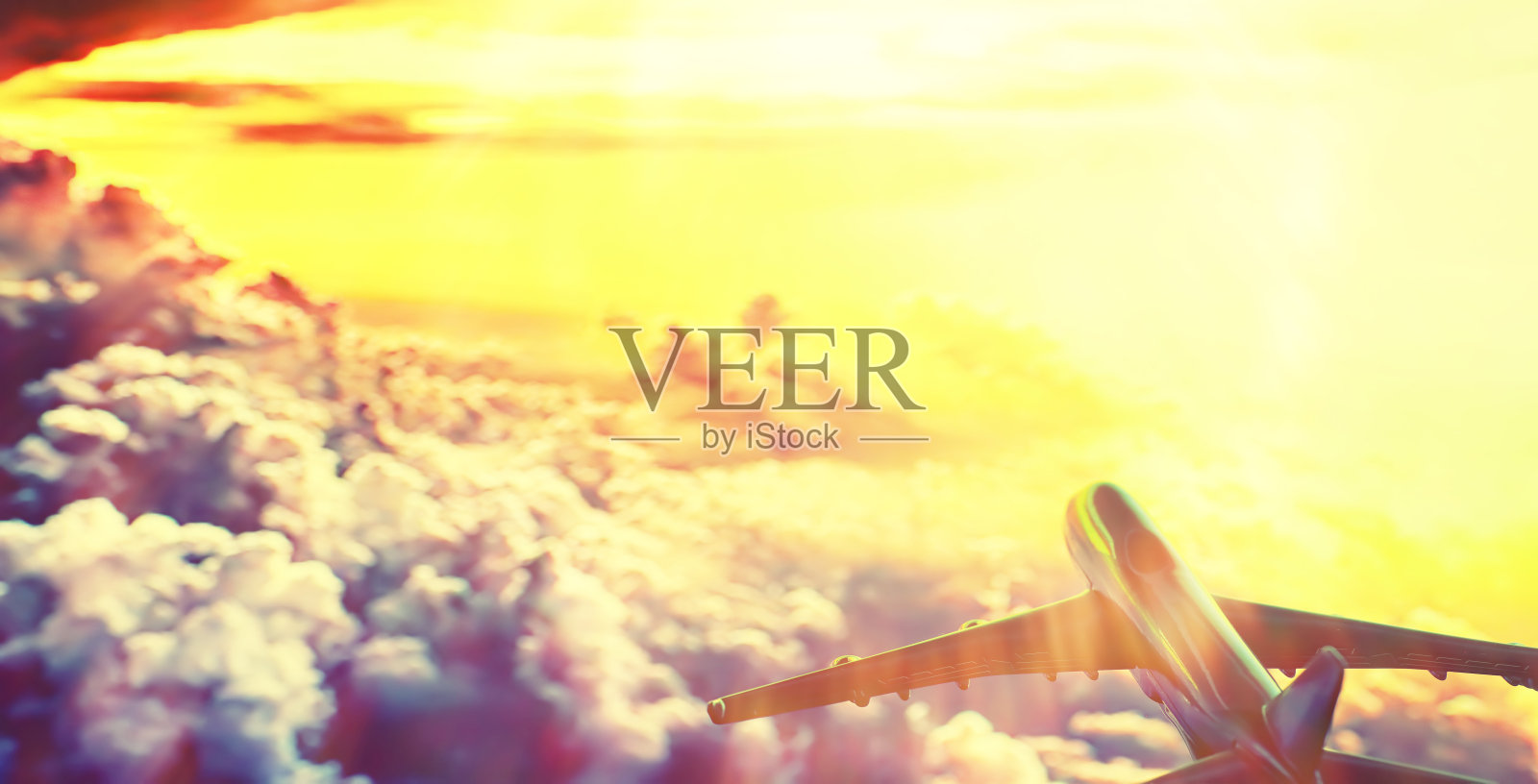 飞机在云层上方的天空中飞行。照片摄影图片