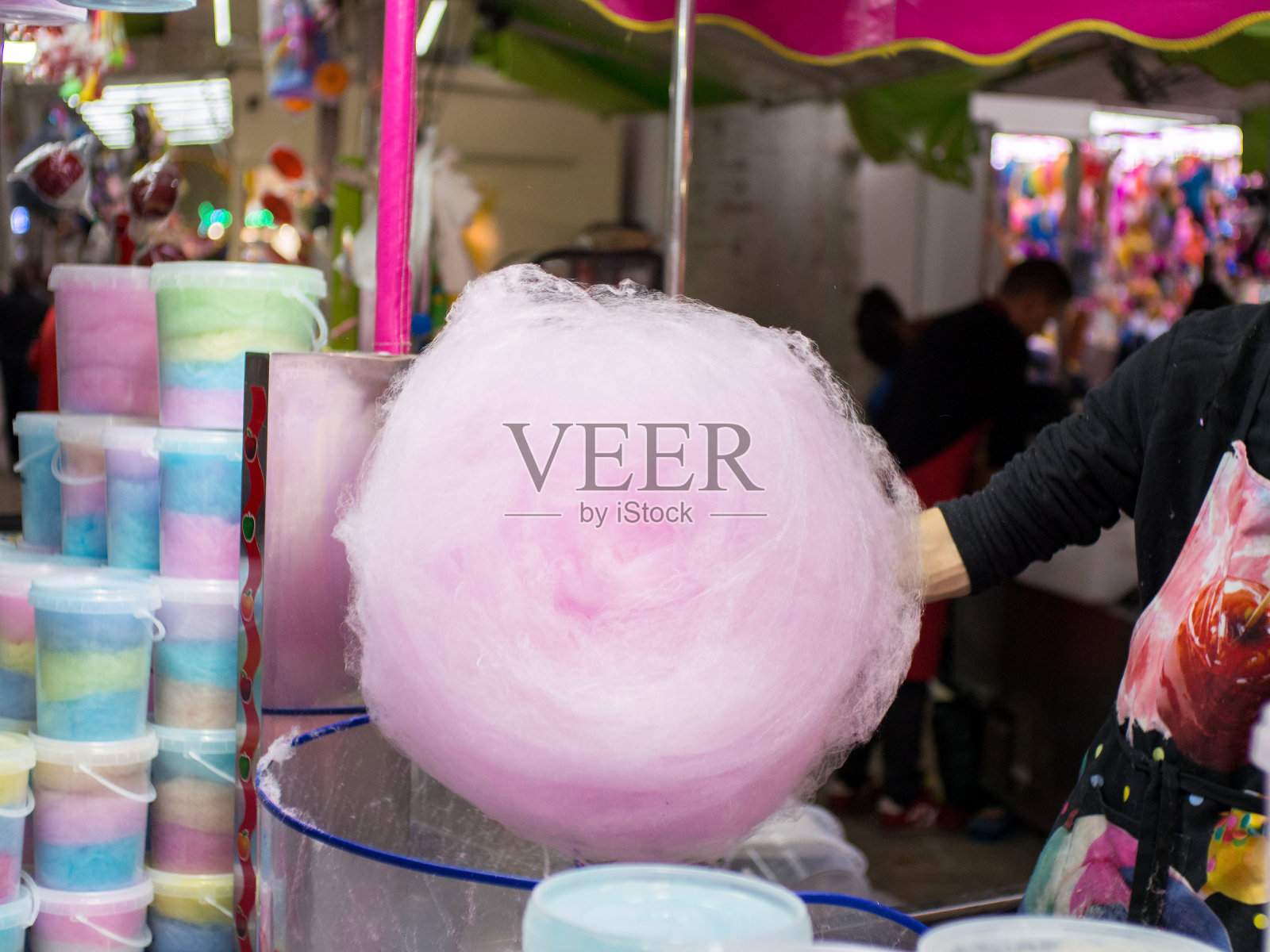 有人在游乐场的摊位上做棉花糖照片摄影图片