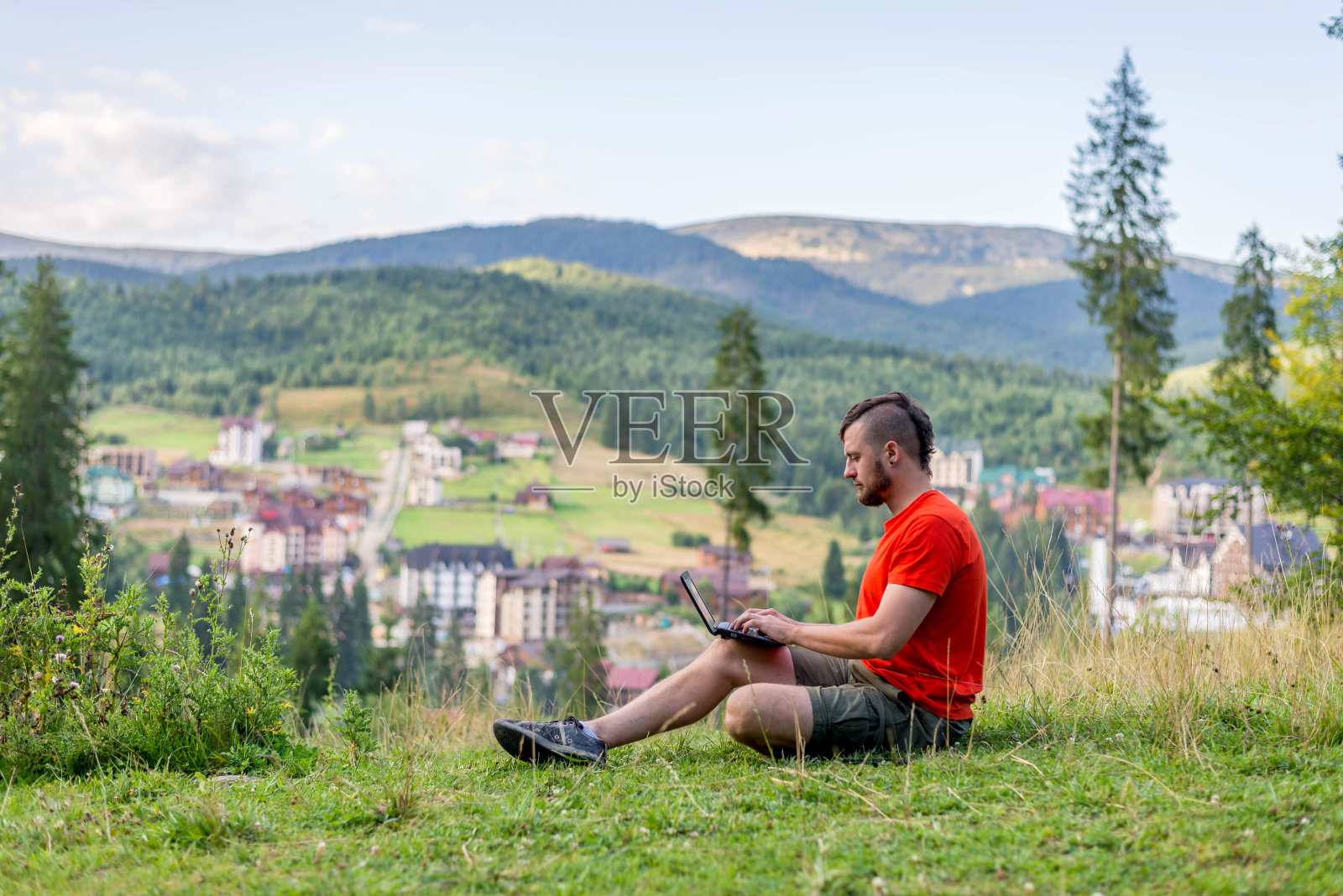 远程工作概念:一个人在户外用笔记本电脑工作。假期工作,工作狂。自由照片摄影图片